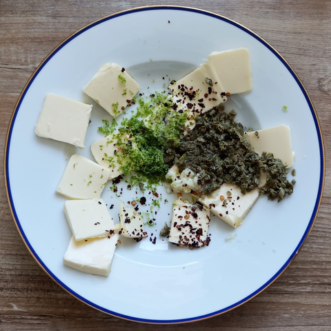Alle Tutaten für die Butter auf einem Teller vor dem Mischen.