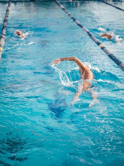man swimming on an indoor swimming pool