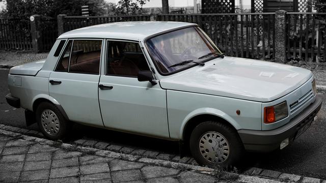 Blau-grauer Wartburg in einem Wohngebiet. Alle Farben außerhalb des Autos entfernt.