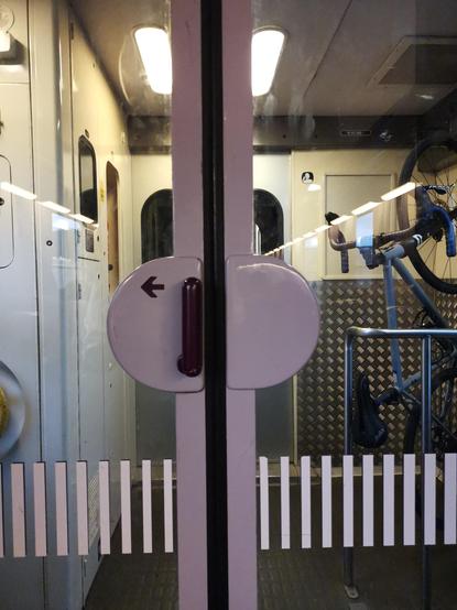 A compartment door : the handle, made of half circles and a rounded mobile part, is a logo in itself.