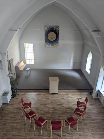 Stuhlkreis vor Rednerpulte in Kapelle.