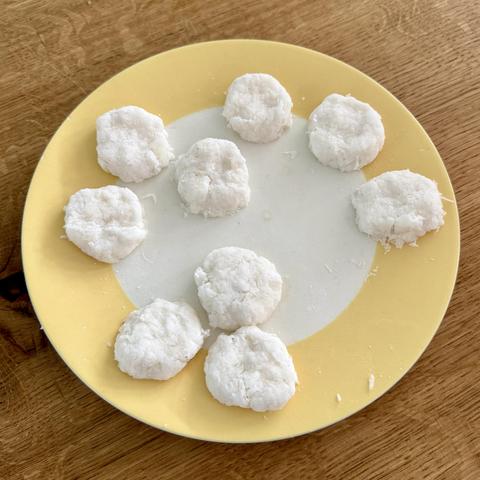 The uncooked daikon fritters on a plate, very white little things.
