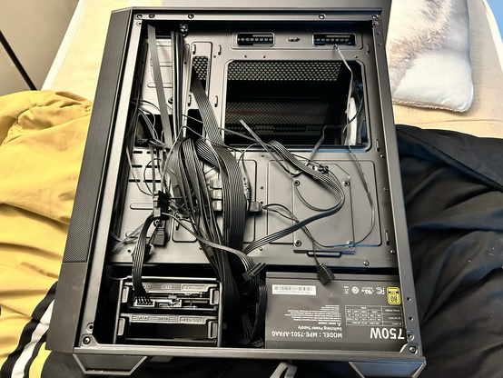 A photo of my WIP PC Build’s back side. In the MSI MAG Forge 112R, there’s a Seagate Barracuda 2TB and a Cooler Master MWE Gold 750 V2. Cable management needs a little bit more work.
