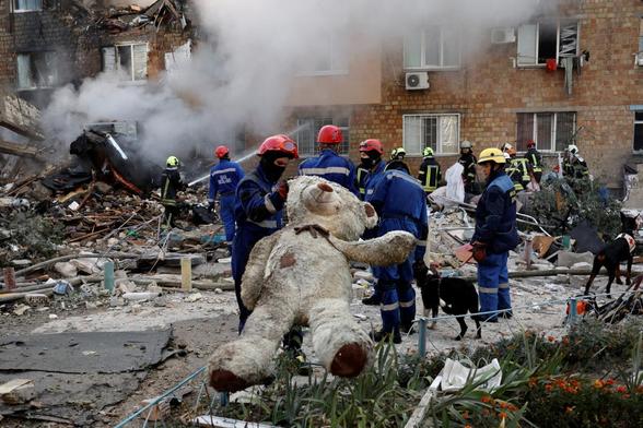 Unos rescatistas sostienen un peluche ante el edificio de apartamentos que fue alcanzado por misiles y drones rusos, el 28 de agosto de 2025. (Thomas Peter / REUTERS)