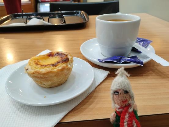 Finger puppet enjoying an early morning pastry and coffee. A pair of glasses on the tray in the background (is it art?)
