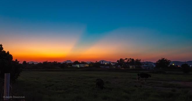 Cienie rzucane na niebie przez wzgórza po zachodzie słońca