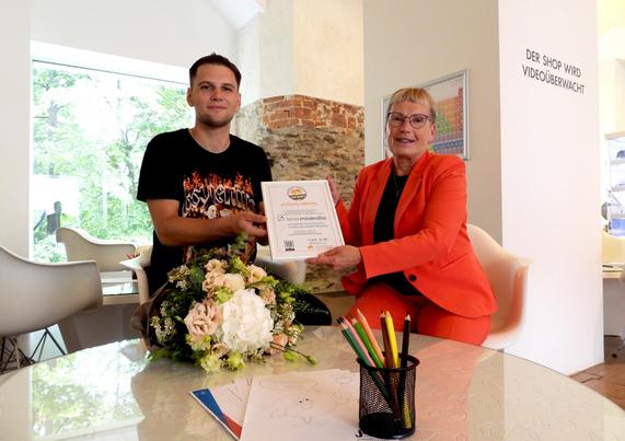 Florian Kröller vom Verband kinderreicher Familien e.V. überreicht das Siegel an terra-mineralia-Geschäftsführerin Andrea Riedel. Foto: TU Bergakademie Freiberg