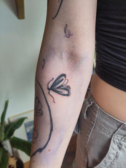 Little moth tattoo on an arm