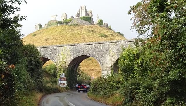 A viaduct/bridge in the foregound. Beyond, an ancient, ruined castle on a hill.