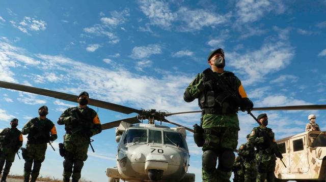 Helicóptero militar en tierra, soldados