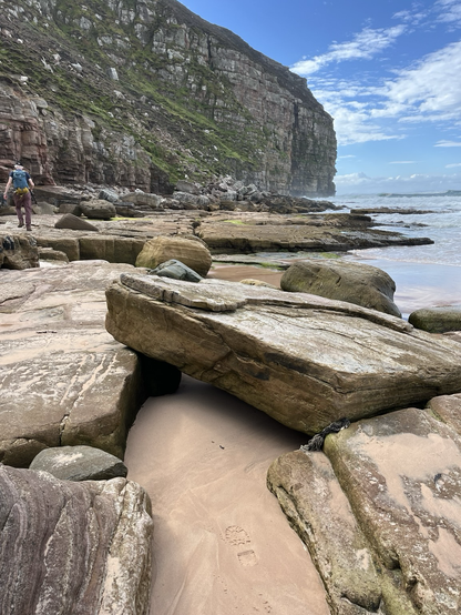 The scene is the cliffs and a rocky shore at Rackwick Bay on Hoy. Orkney Islands.