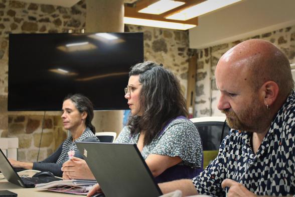 Komunitateko hiru kide Torrekuan ordenagailuekin bileran.