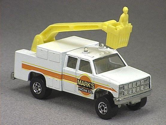 Released in 1984, White Phone Truck of 1984 Hot Wheels with Black Wall wheels. Notes: Yellow plastic boom and clear lights on top. Tampo: Orange, yellow and black stripe with 'Mark's Phone Co. On sides. Packaging: 1984 Blister. Metal Body, Metal Base. Made in Malaysia. Scarcity: 4/10