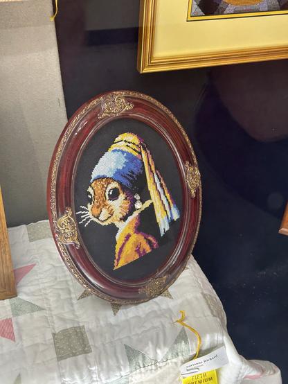 A parade of the girl with pearl earring but she’s a squirrel. The piece is cross stitched.