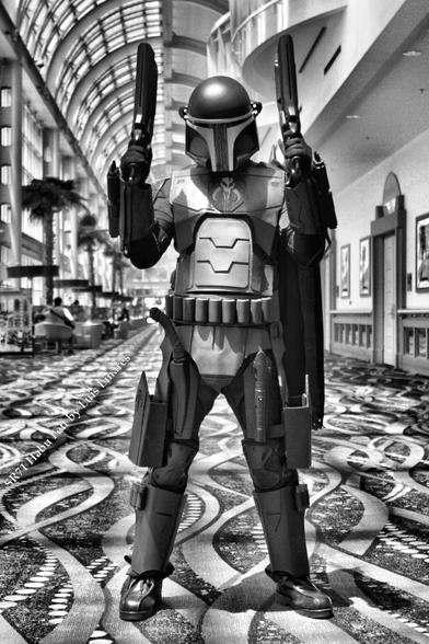 SR71 Habu Fett from Long Beach Comic Con 2014

Cosplayer - Luis Linares

Star Wars cosplay of Boba Fett with modifications.  This image is in black and white, but we have the color version as well.  Standing center frame with dual pistols point up arms bent at the elbows.  Mando crest center of chest plate just below chin.