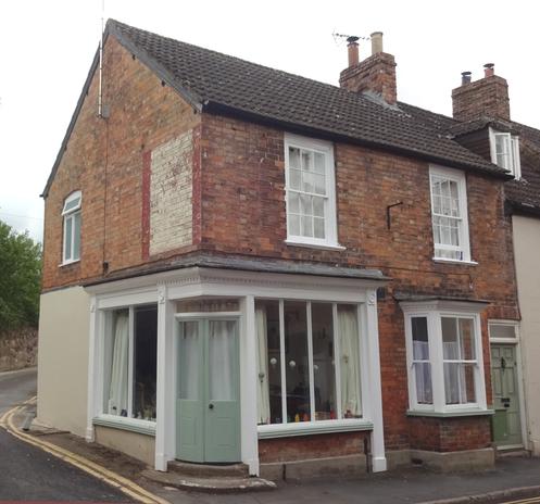 A corner shop with a cute, curved door.