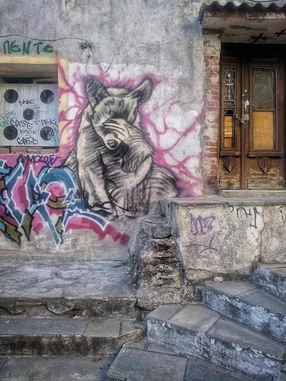 Wall with graffitto of cat (?) with paw before eyes