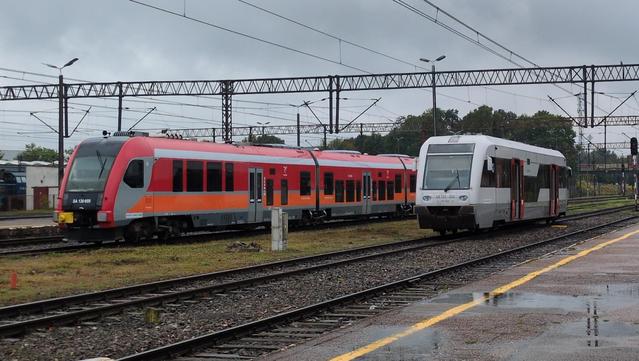 Dwa szynobusy na bocznicy. Po lewej stronie trójczłonowy SA136 we współczesnym czerwono-pomarańczowo-szarym malowaniu PolRegio. Po prawej jednoczłonowy SA103, w białym malowaniu województwa pomorskiego.