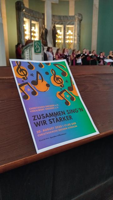Prospekt auf Kirchenbank mit "zusammen singen wir stärker" im Hintergrund chortissimo beim warmsingen.