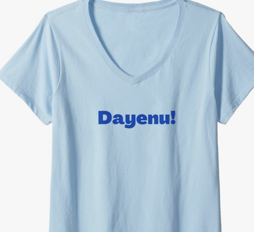 Dayenu is shown in blue lettering on a V neck T shirt.