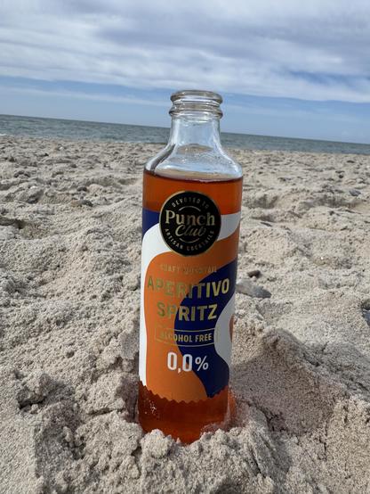 Eine kleine Glasflasche am Strand im Sand stehend, im Hintergrund die Nordsee und leicht bewölkter Himmel:
PunchClub
CRAFT MOCKTAIL
APERITIVO SPRITZ
ALCOHOL FREE 0,0%