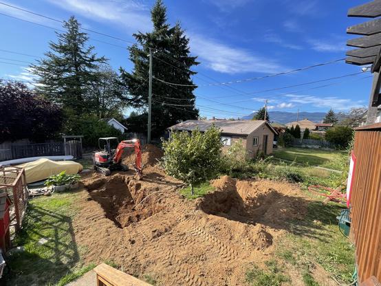 A view from Labour Day 2024. Shows the digger sitting behind the freshly dug pool pond hole.