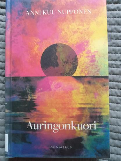 Kirjan kannessa on punaisen ja keltaisen sävyissä hehkuva maalaus mereen laskevasta auringosta.
