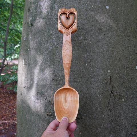 Wooden spoon held in front of a beech tree.
