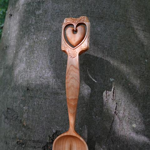 Wooden spoon held in front of a beech tree.