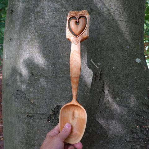 Wooden spoon held in front of a beech tree.