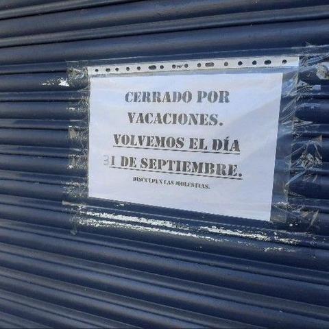 "Cerrado por vacaciones. volvemos el día 31 de septiembre" folio batean idatzita eta denda pertsiana batean jarrita. Dena ordenagailuz idatzita 3 izan ezik.