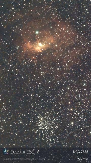 A cloud of glowing gas with a bubble in it above a loose ball of stars.