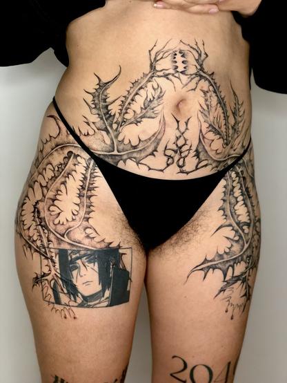 Tattoo of thistles on legs and belly