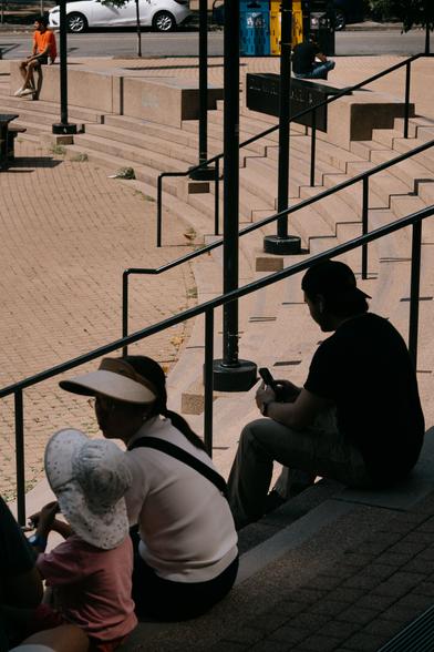 People at rest by the stairs at the library.