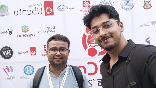 Me (Left) with Faraz Khan (Right), a member of the community, in front of the UbuCon sponsors board. Faraz Khan taking the selfie.