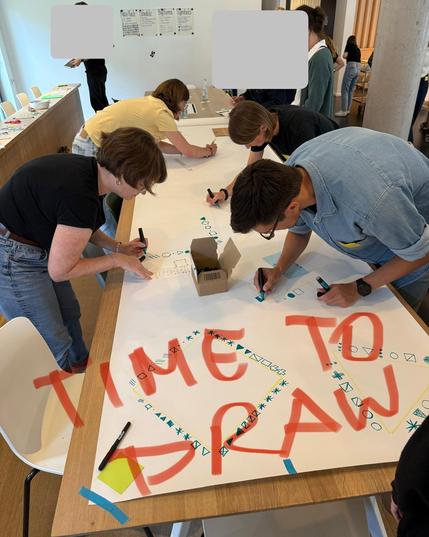 participants drawing on a big sheet of paper