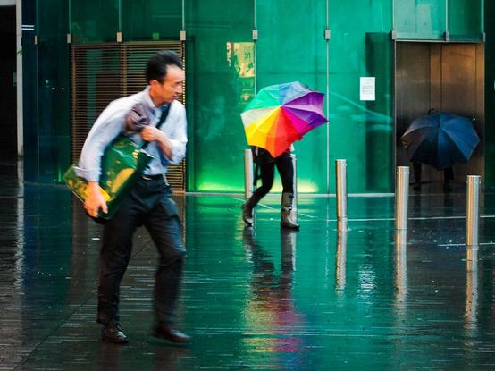 A man with no umbrella rushes out into the typhoon rain.