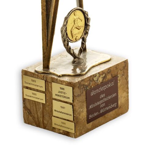 Fußballpokal des Ministerpräsidenten von Baden-Württemberg. Detailaufnahme Sockel: Zu sehen sind die Plaketten der Sieger-Ministerien von 1986 bis 1990.
Foto: Marcella Müller / Hauptstaatsarchiv Stuttgart