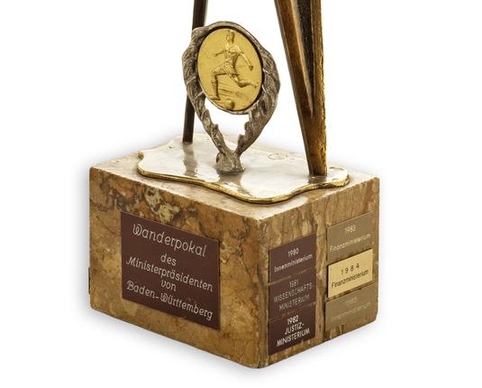 Fußballpokal des Ministerpräsidenten von Baden-Württemberg. Detailaufnahme Sockel: Zu sehen sind die Plaketten der Sieger-Ministerien von 1980 bis 1985.
Foto: Marcella Müller / Hauptstaatsarchiv Stuttgart