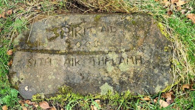 A stone with the words Spirit Aid 2002 Sith Air Thalanh carved roughly into it.