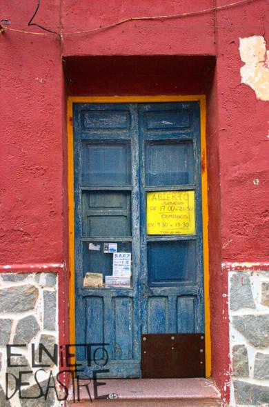 titulo; abierto, puerta de una tienda con colores rojos y azules.