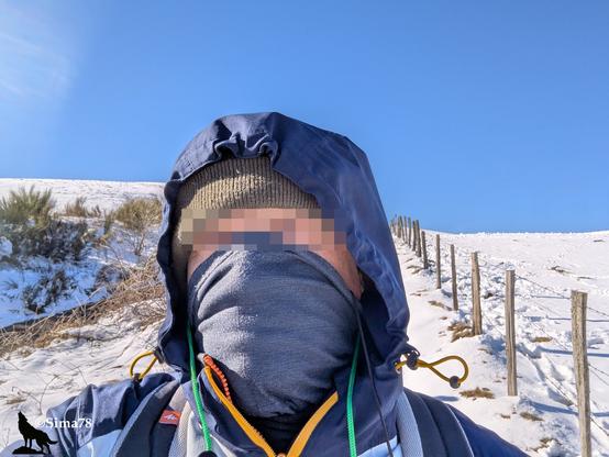 Selfie (yeux floutés) en veste à capuche par temps ensoleillé dans un paysage enneigé.
Selfie (eyes blurred) in a hooded jacket on a sunny day in a snowy landscape.
Selfi (ojos difuminados) con chaqueta con capucha en un día soleado en un paisaje nevado.