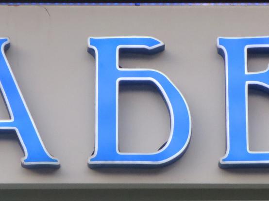 Синяя буква Б с тонкой белой обводкой, исполненная в винтажной стилистике. Фрагмент логотипа ресторана. // A blue letter Б (Cyrillic B) with a thin white outline, done in a vintage style. A fragment of a restaurant logotype (and signboard).