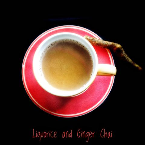A cup of liquorice and ginger chai, with a piece of liquorice root.