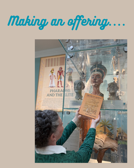 A sandy background, with teal text reading "Making an offering...".
In the lower right corner, a photo of me, back to the camera, holding the book "Dreams Of Amarna" up in front of the case containing busts of Akhenaten, Nefertiti and Tuntankhamen, in the classic offering pose.