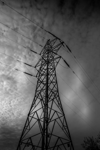 monochrome shot up electric pylon into cloud rippled sky