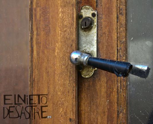 Una maneta de metal brillante y negro de una puerta antigua.
