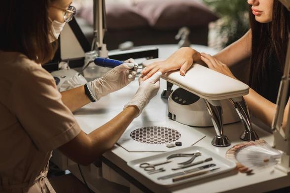 Una persona, haciéndole las uñas a otra. (Getty Images)
