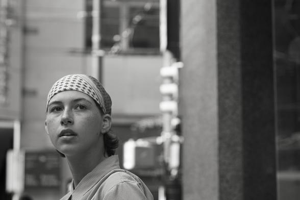 A woman looks down the road into the distance.