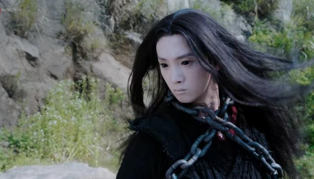 Ghost General Wen Ning makes an unexpected entrance, hair loose, eyes completely black, and a chain wrapped around his torso so that an X is formed just below his neck.